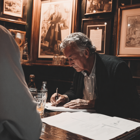 colour photograph of a man selling his british pub, signing documents, old man